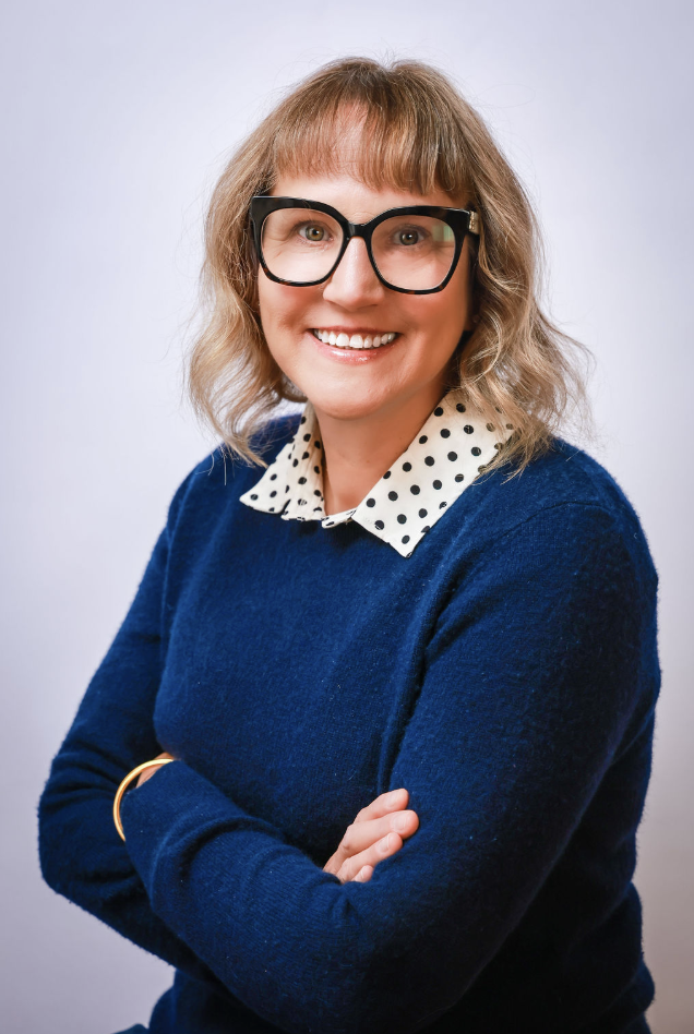 Tracey smiling in a navy sweater